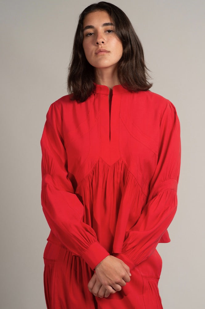 Una mujer viste la blusa Montería roja de manga larga hecha de cupro de Yakampot, 11 años de Moda Mexicana que combina técnicas ancestrales con diseño contemporáneo
