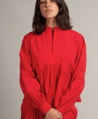 Una mujer viste la blusa Montería roja de manga larga hecha de cupro de Yakampot, 11 años de Moda Mexicana que combina técnicas ancestrales con diseño contemporáneo