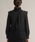 Una mujer de espaldas con una Blusa Mazahua Negra con plisados de la marca Yakampot, 11 años de Moda Mexicana Contemporánea