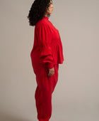 Una mujer XXL viste la blusa Montería roja de manga larga hecha de cupro y un pantalón rojo de corte recto con plisados de la marca Yakampot, moda mexicana que combina técnicas ancestrales con diseño contemporáneo